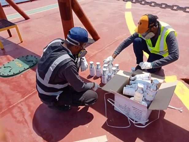 Two Muna Noor technicians preparing a fumigation on a container ship deck